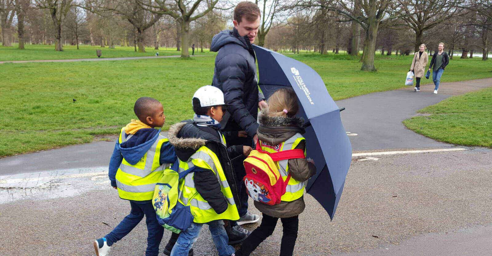 Kids with father under umbrella